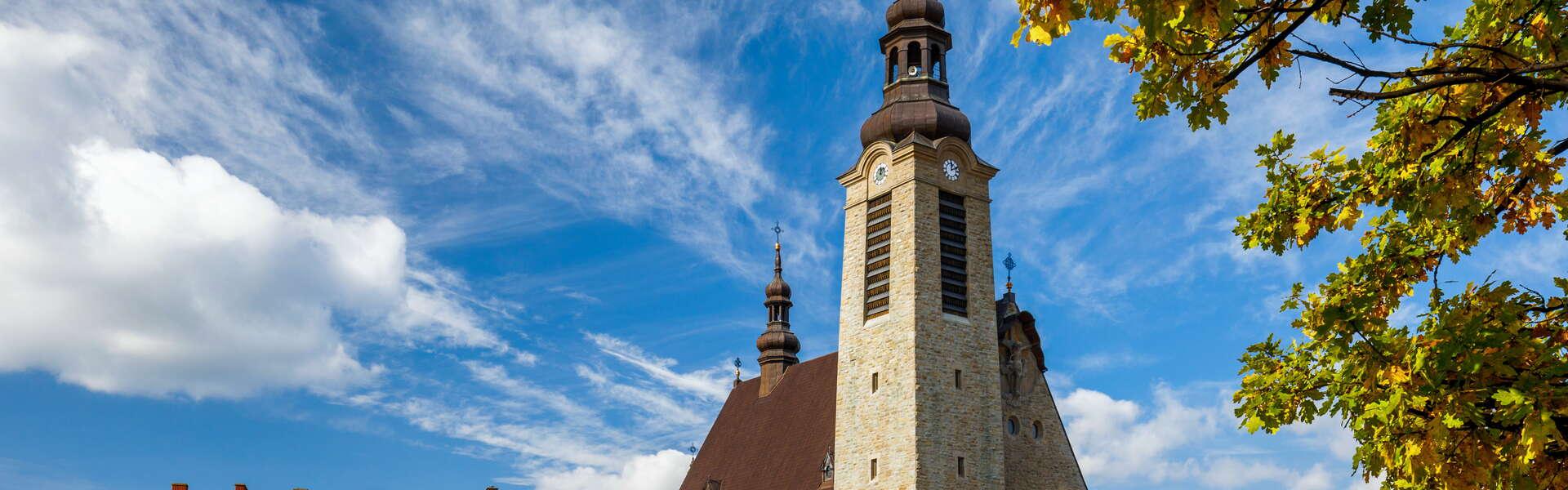 The town square with a soaring stone church tower in the background